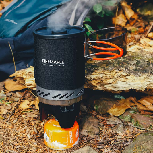 Firemaple camping stove with a fuel canister on a natural outdoor setting