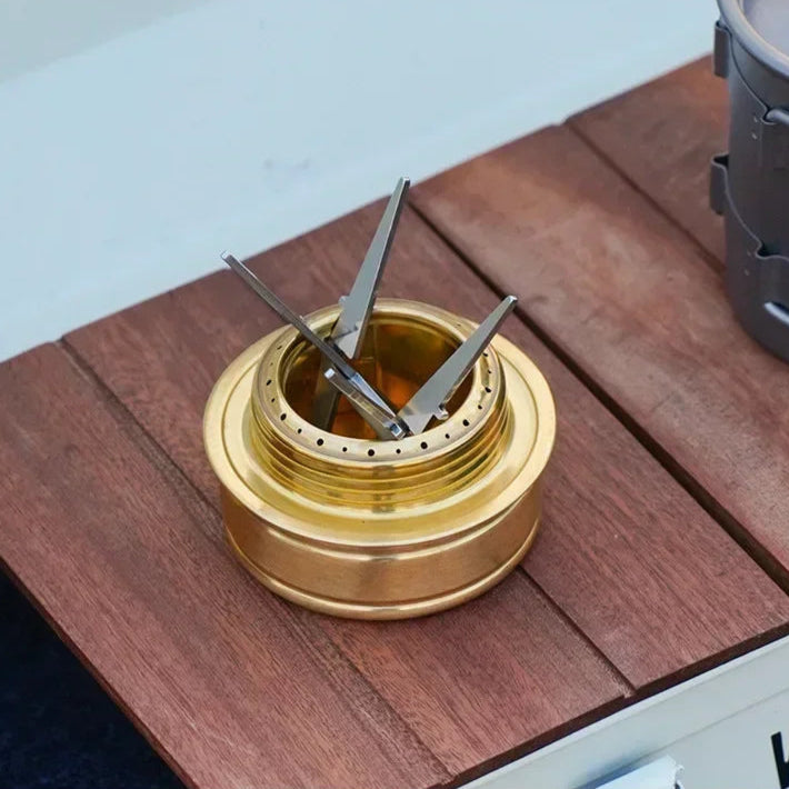 Gold-colored metal object with three prongs on a wooden surface