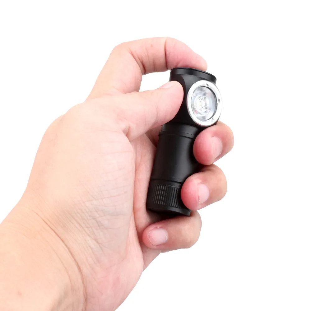 Hand holding a black flashlight with a white background