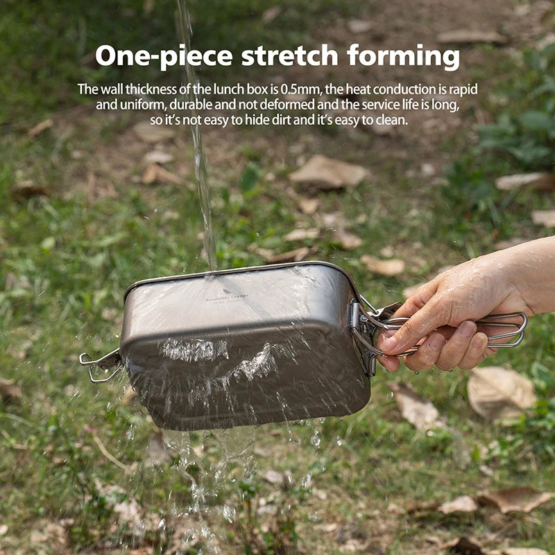 Person holding a metal lunch box outdoors with water being poured over it.