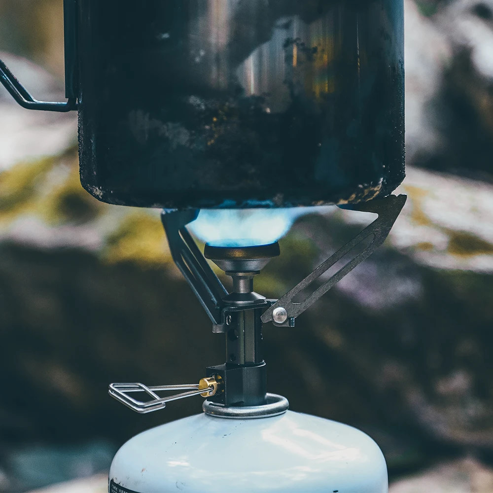 Close-up of a camping stove with a blurred natural background