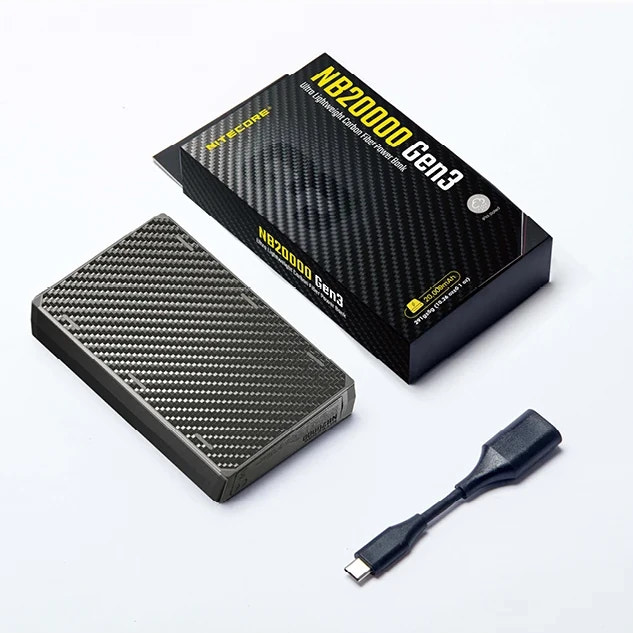 Portable power bank with carbon fiber design, packaging, and USB cable on a white background