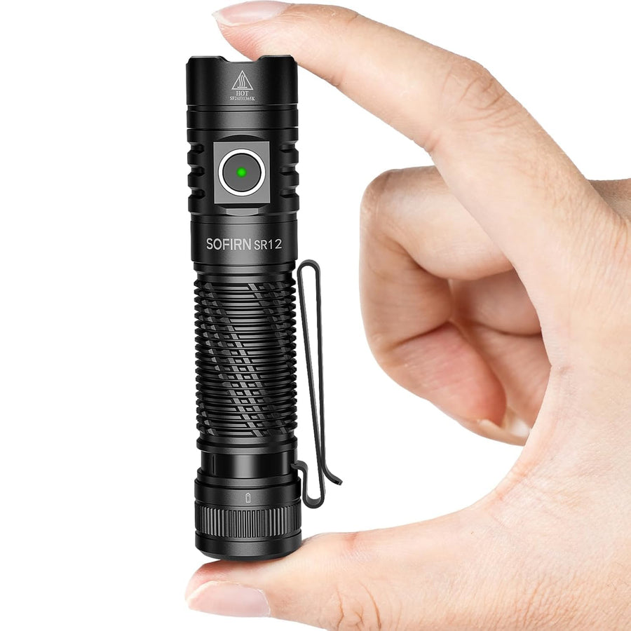 Black flashlight held in a hand with a white background