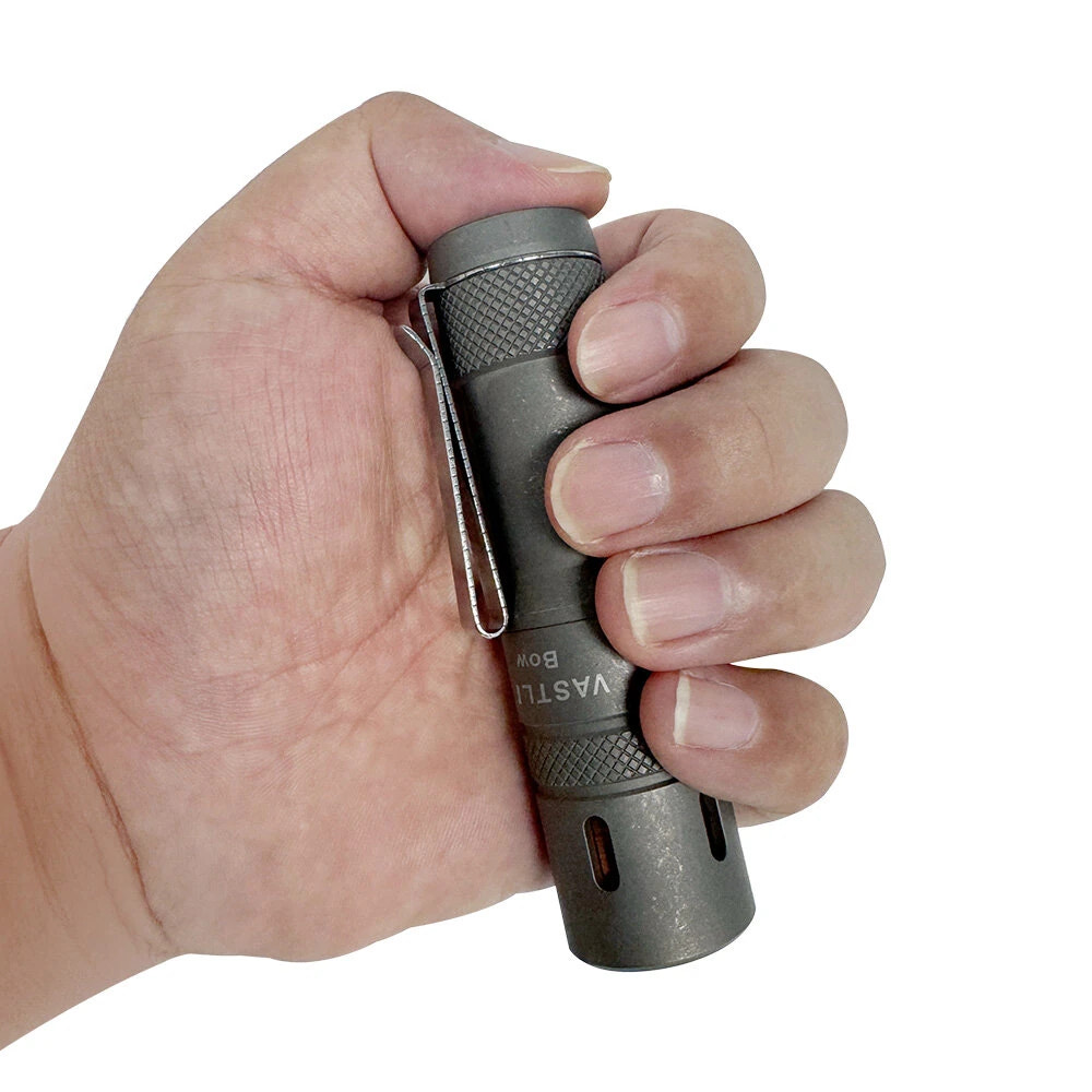 Hand holding a VASTLITE branded flashlight against a white background