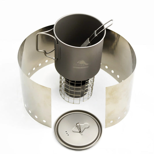 Portable camping stove with cup and windscreen on a white background