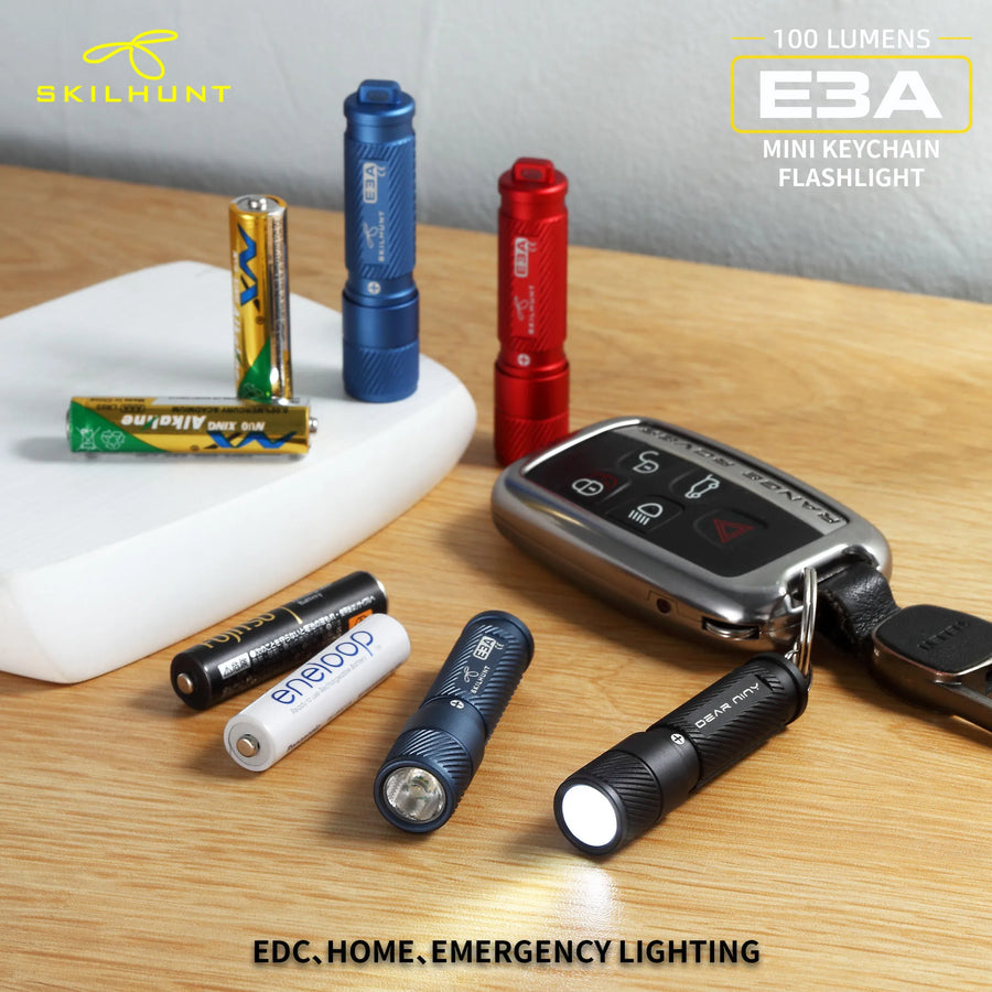 Collection of mini keychain flashlights on a wooden surface with batteries and a car key fob.