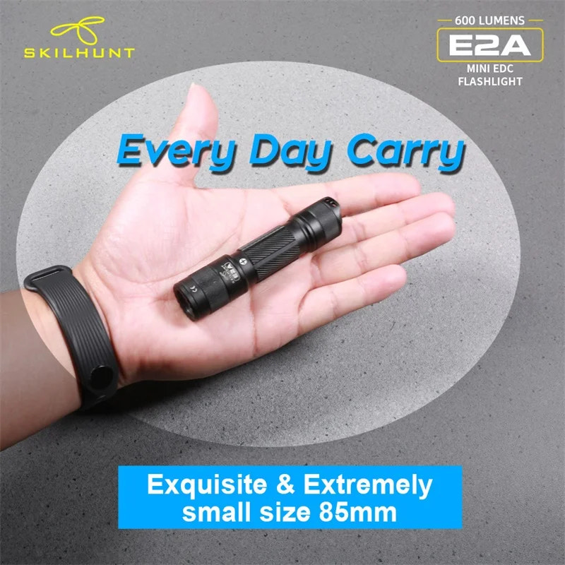 Skilhunt E2A mini EDC flashlight held in a hand with promotional text on a gray background