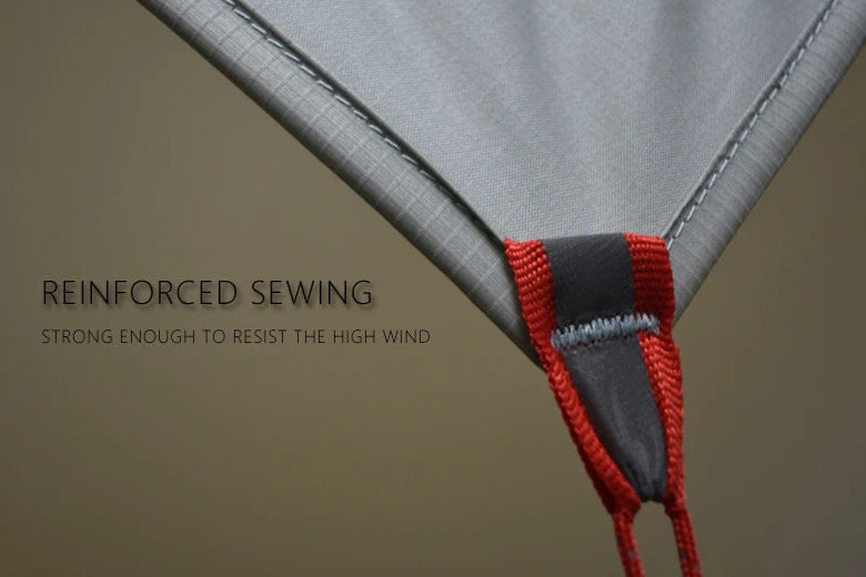 Close-up of a tent with reinforced sewing and red binding on a beige background.