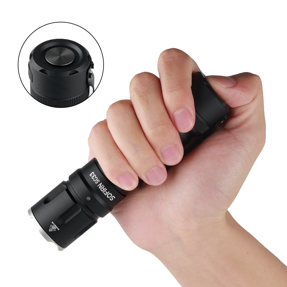 Hand holding a black flashlight with close-up inset on a white background