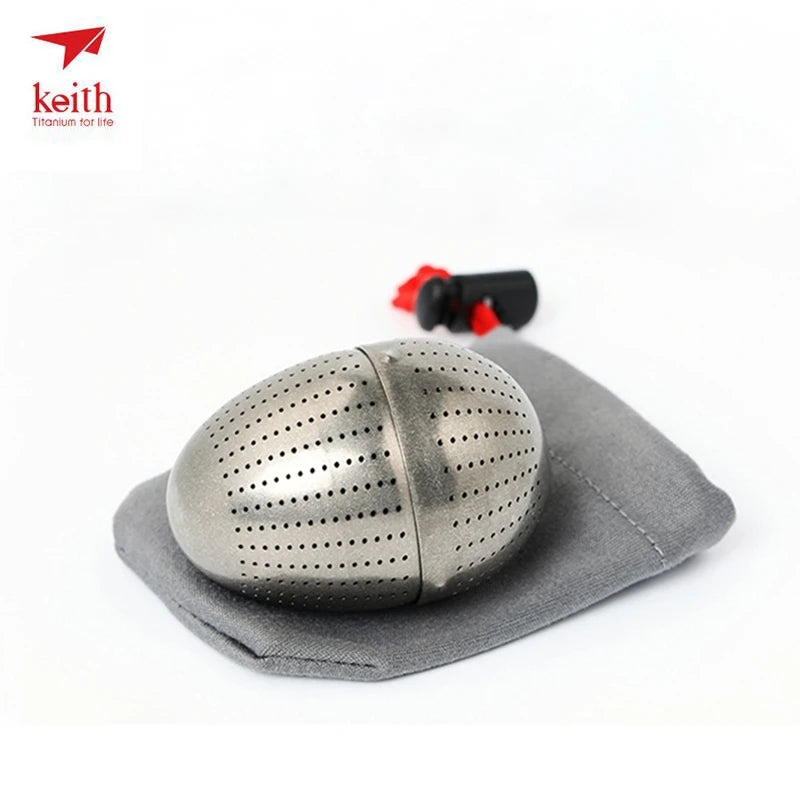 Metal tea ball with a gray cloth on a white background, featuring the Keith brand.