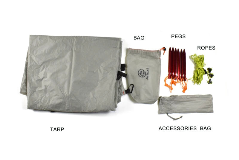 Outdoor gear set including a tarp, accessories bag with pegs and ropes on a white background.