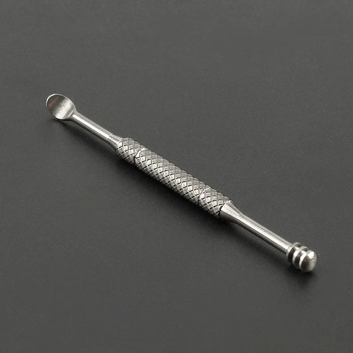 Metal tool with textured design on a dark gray background