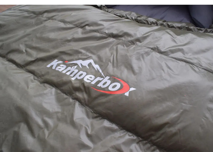 Green sleeping bag with Kampa logo on a plain background