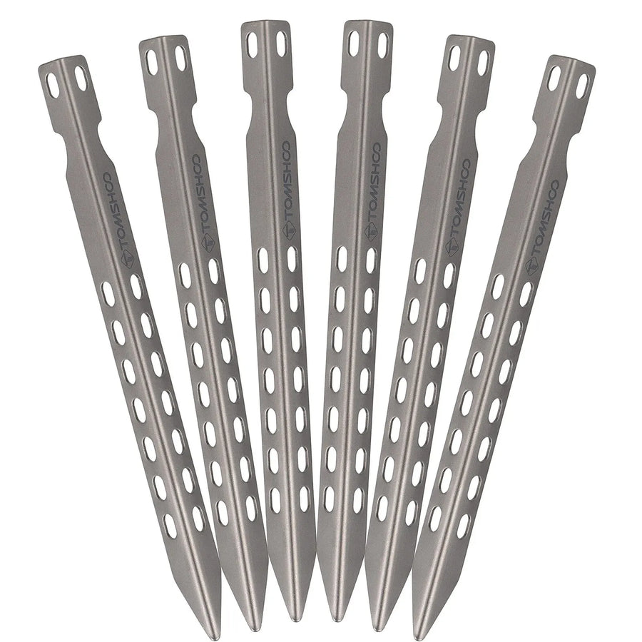 Set of six titanium tent stakes on a white background