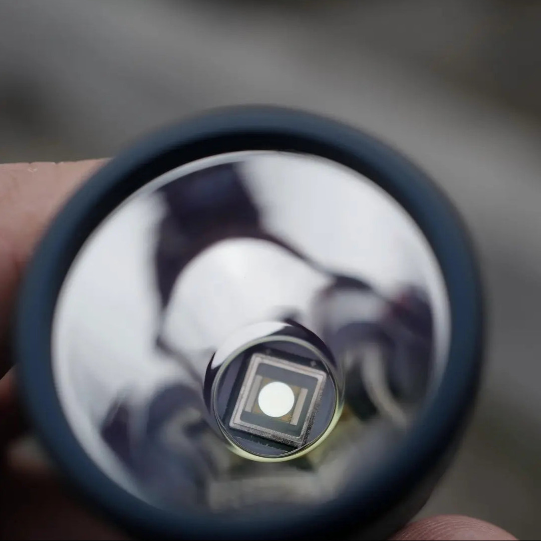 Close-up of a small round object with reflective surface held by a hand.
