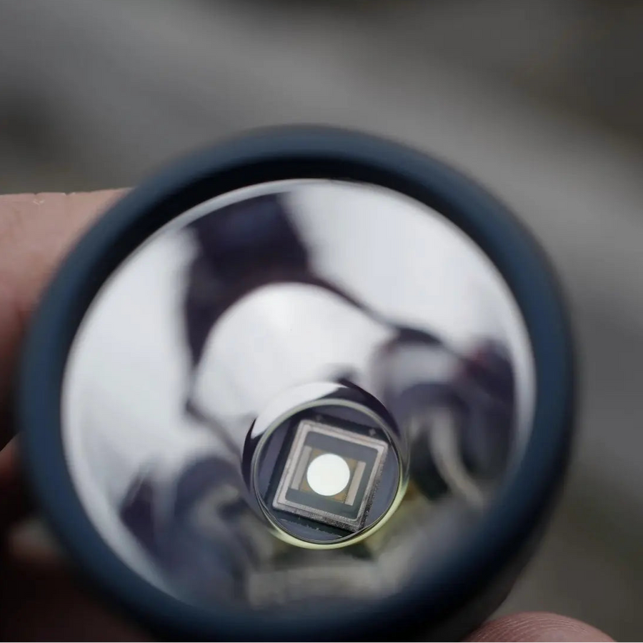 Close-up of a small round object with reflective surface held by a hand.