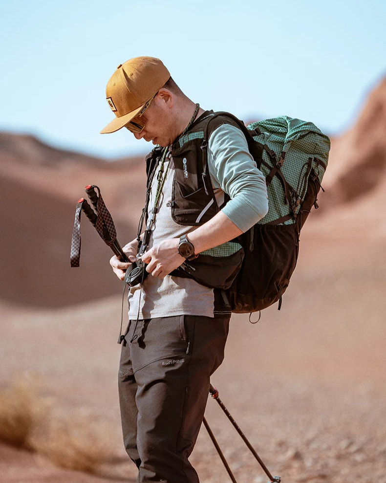 Person hiking in a desert with a backpack and walking sticks