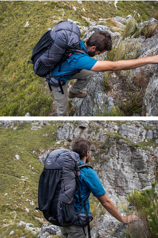 Hiker with a large backpack scaling a rocky mountain