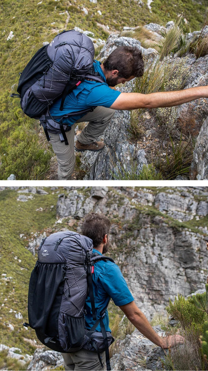 Hiker with a large backpack scaling a rocky mountain