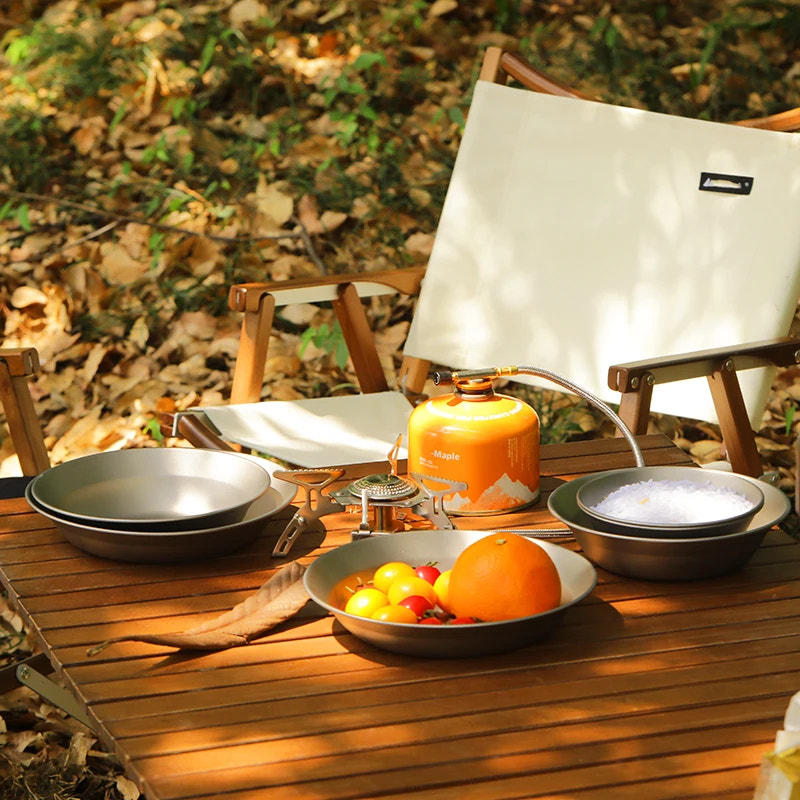 Outdoor setting with a table, chair, and camping stove in a natural setting.