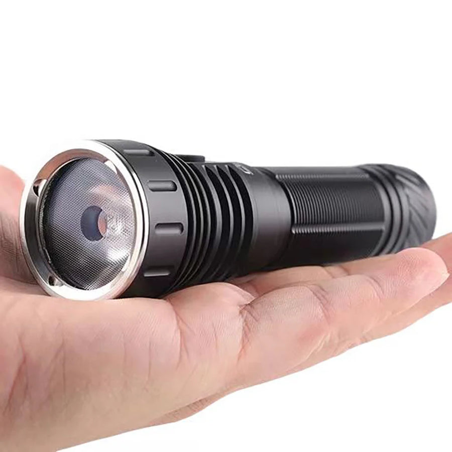 Black flashlight held in a hand against a white background