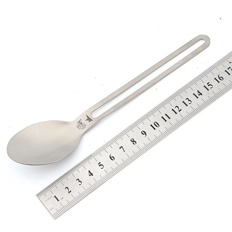 titanium spoon next to a ruler on a white background