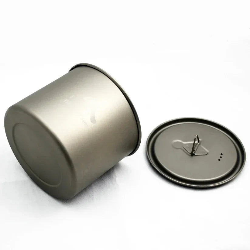 Metallic cylindrical container with a lid on a white background