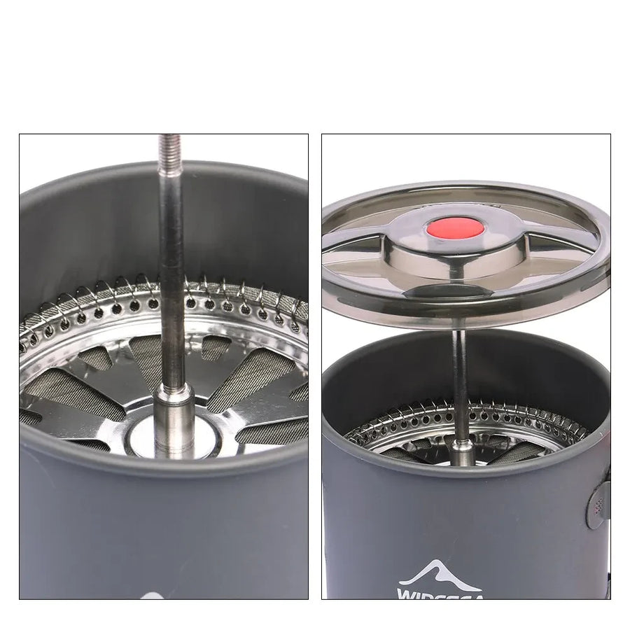 Close-up of a gray coffee maker with a red button and metal components on a white background.