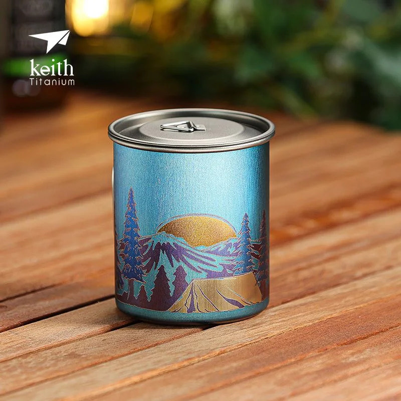Blue mug with mountain design on a wooden surface, featuring the Keith Titanium logo.