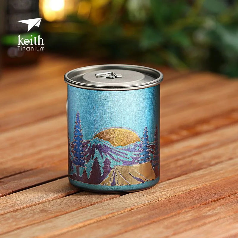 Blue mug with mountain design on a wooden surface, featuring the Keith Titanium logo.