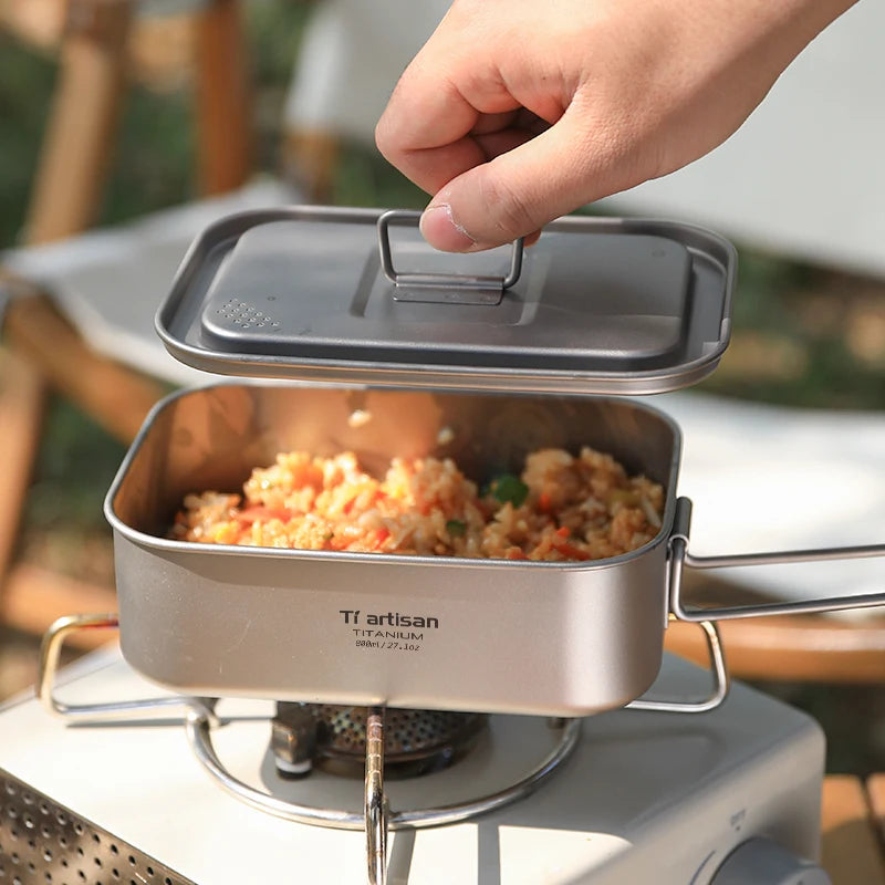 titanium food container with food on a camping stove