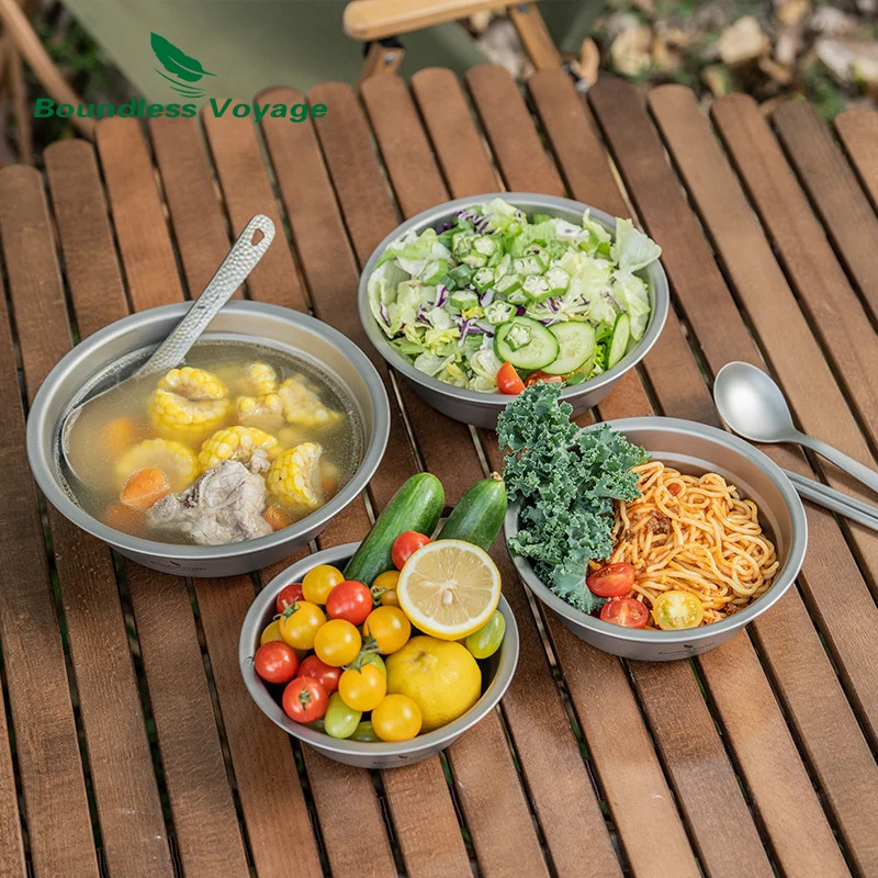 Assorted dishes including soup, salad, noodles, and vegetables on a wooden table with 'Boundless Voyage' branding.