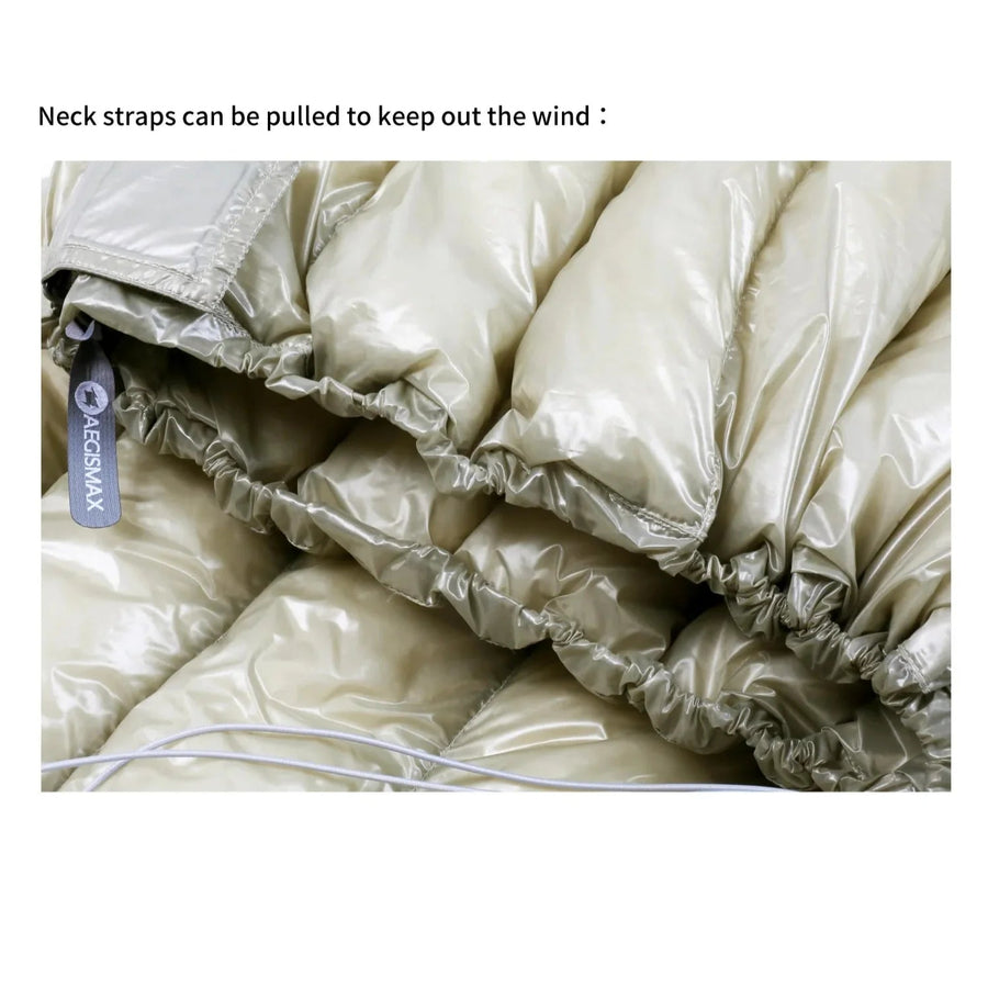 Folded beige sleeping bag with neck straps and Aecon Max label