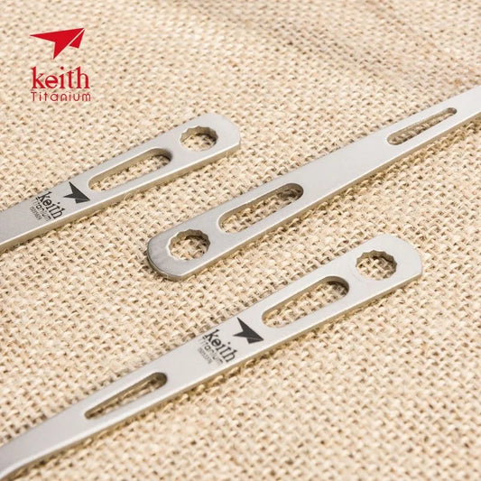 titanium spoon handles with 'Keith Titanium' branding on a beige fabric background.