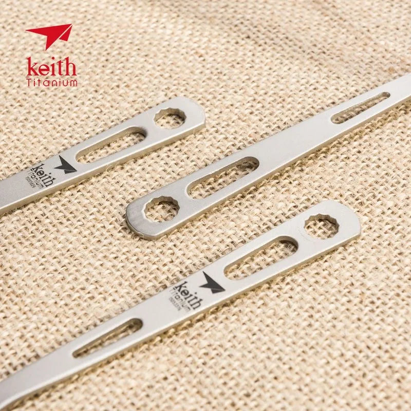 titanium spoon handles with 'Keith Titanium' branding on a beige fabric background.