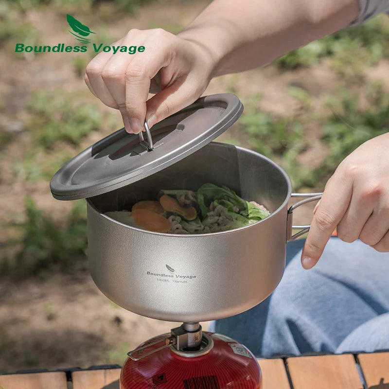 Person using a portable camping stove with a pot containing food, branded 'Boundless Voyage'.