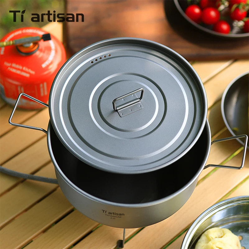 Portable camping stove with gray lid on a wooden surface, featuring Tiartisan branding.