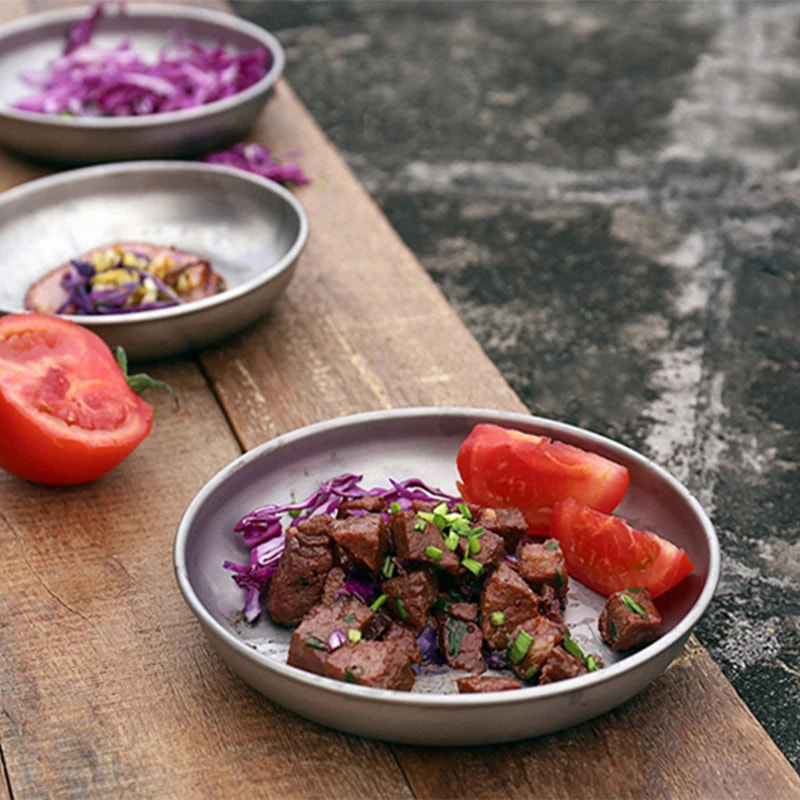 Plated dish of meat with vegetables on a wooden table