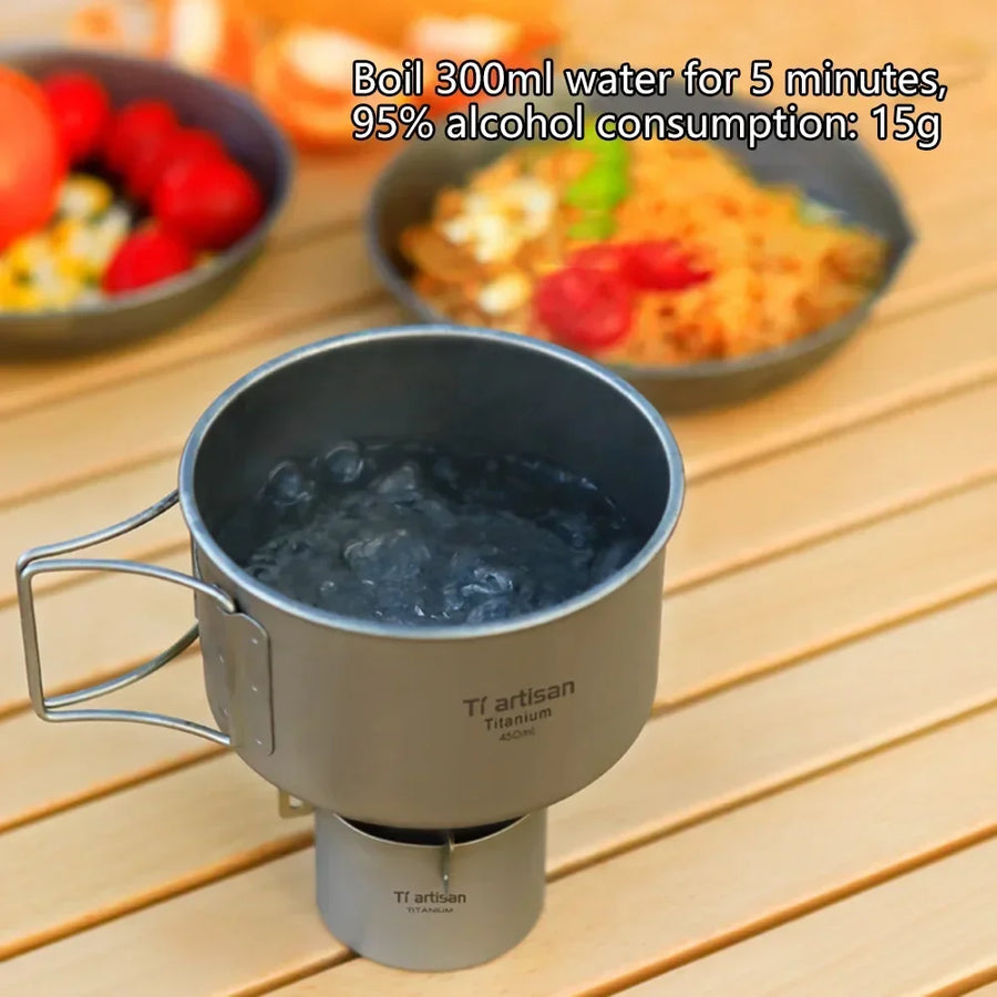 Metal mug with water on a stove on a wooden surface with food in the background