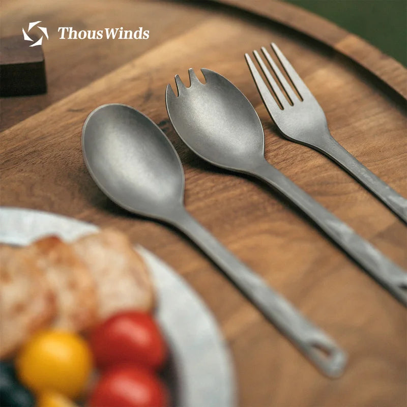 Titanium cutlery set on a wooden surface with 'ThousWinds' branding.