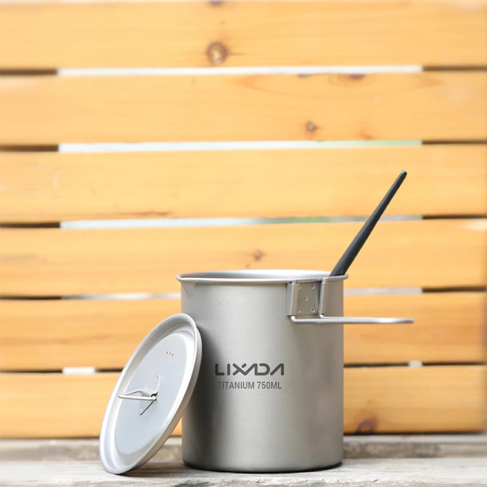 titanium camping mug with lid and straw on a wooden surface