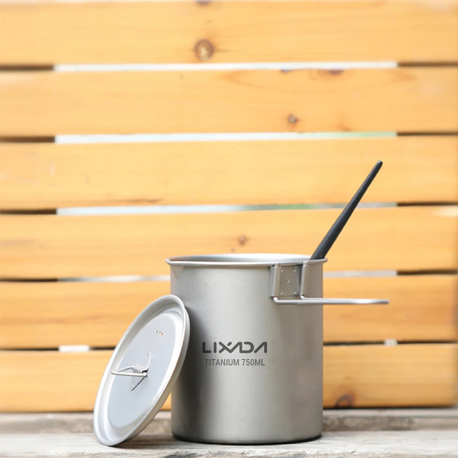 titanium camping mug with lid and straw on a wooden surface