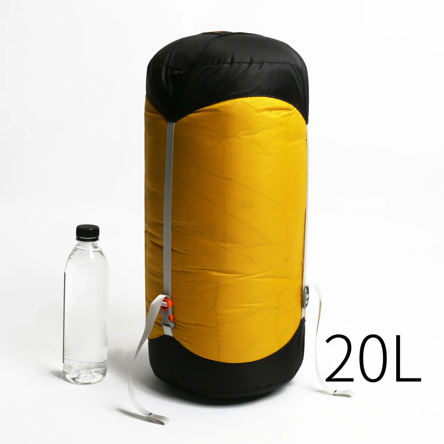 Yellow and black sac with a water bottle for scale on a white background