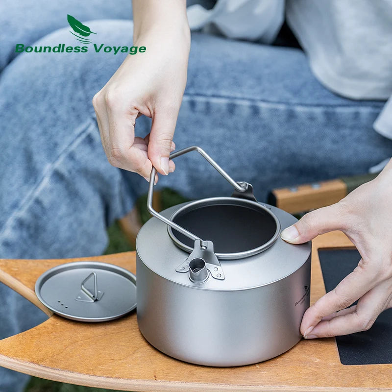 Person using a silver camping pot with a wooden table and blurred background