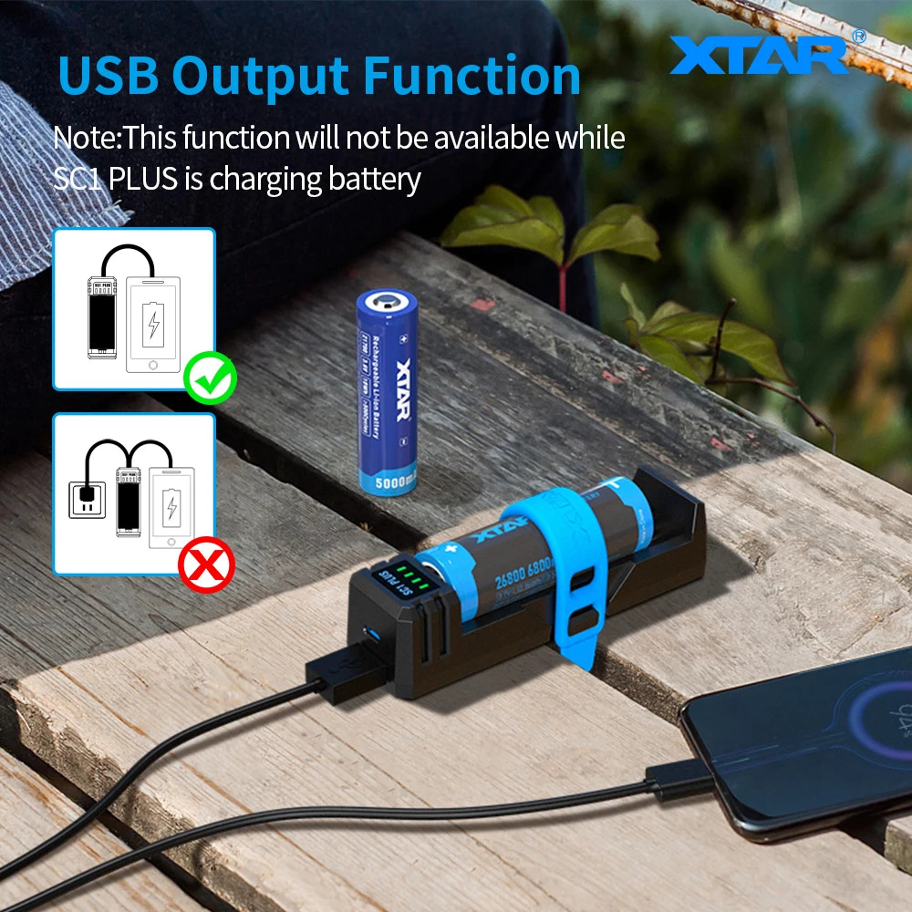 Battery charger with USB output function and XTAR branding on a wooden surface.