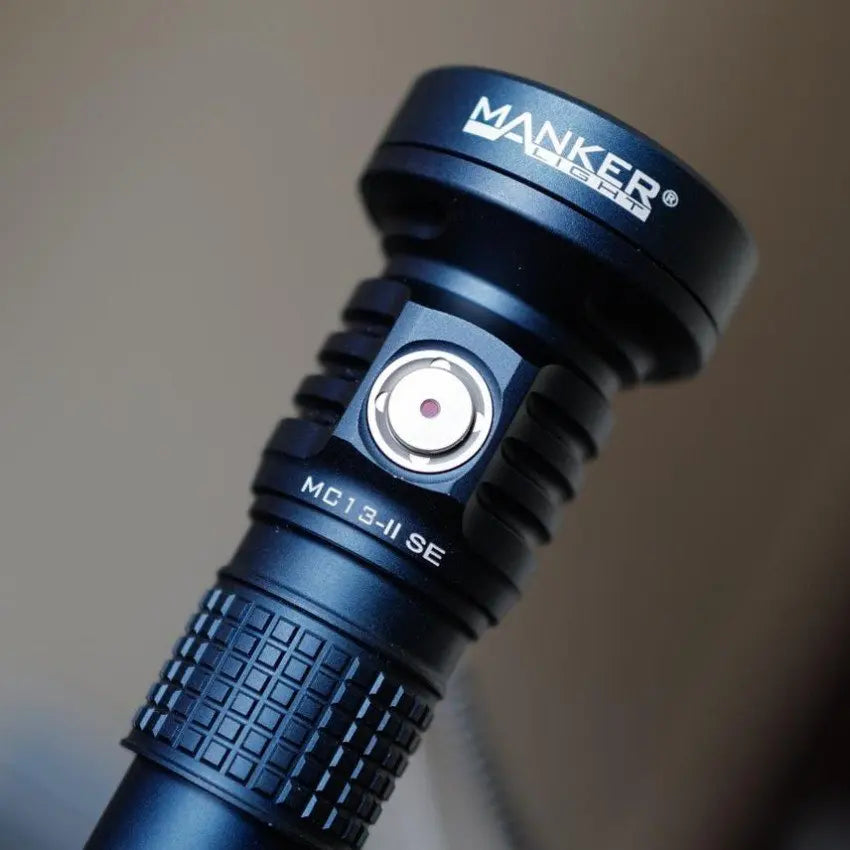 Blue flashlight with MANKER branding on a blurred background