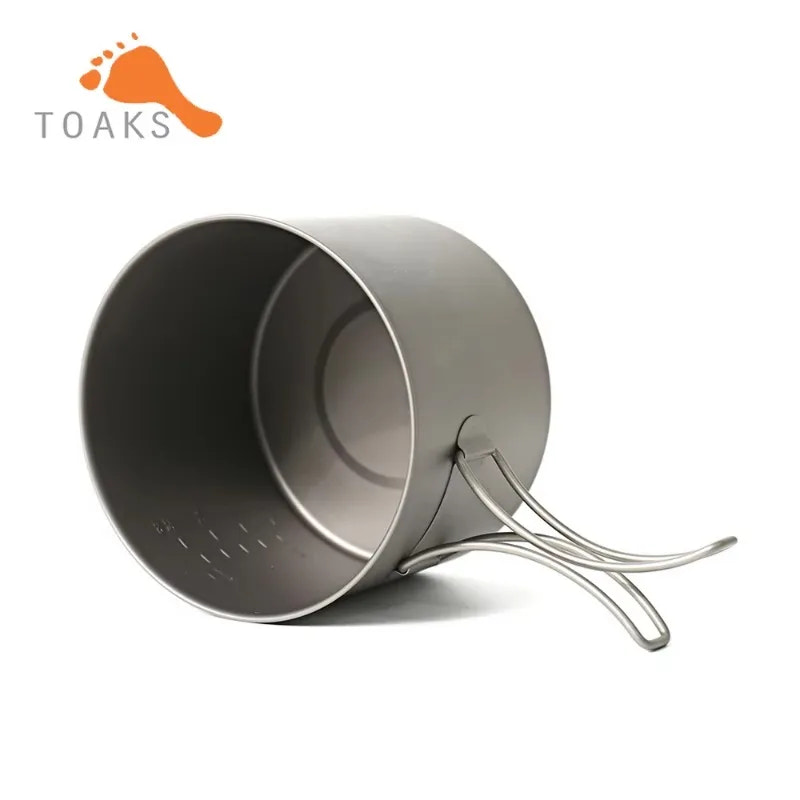 Metal camping pot with handle on a white background, featuring the Toaks brand logo.