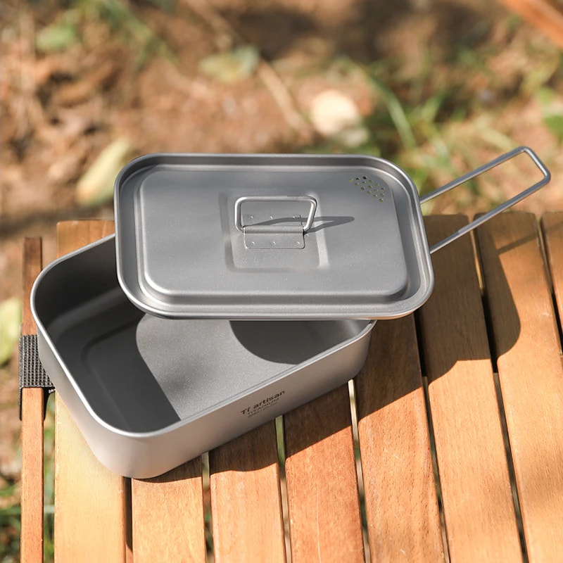 Camping cookware set on a wooden surface with a natural background