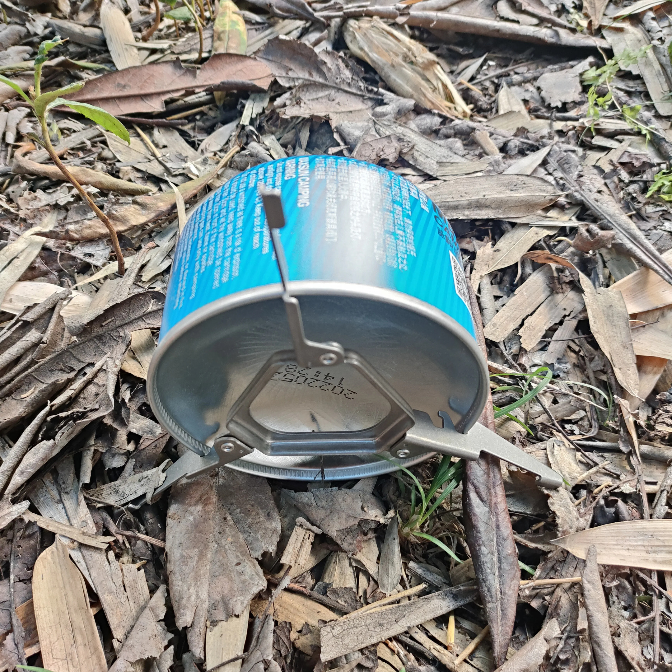 Aluminum can on the ground with a blue label