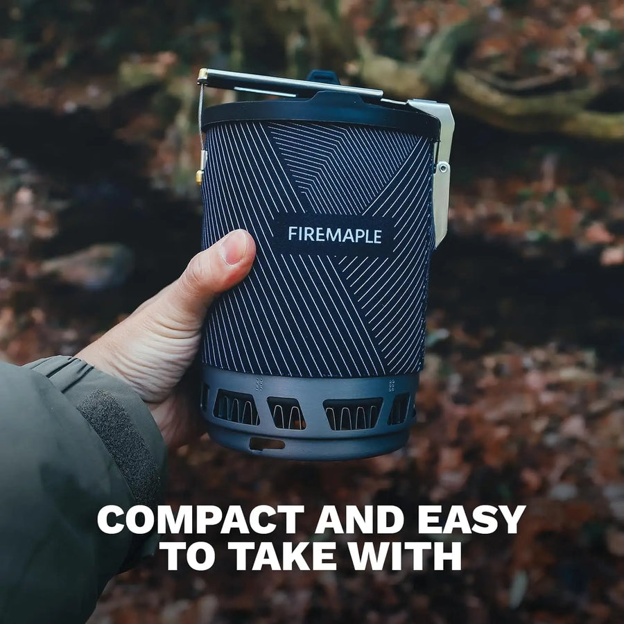 Hand holding a Firemaple portable stove with a natural background